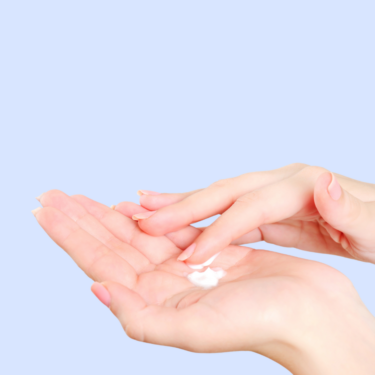 woman moisturizing hand with lotion
