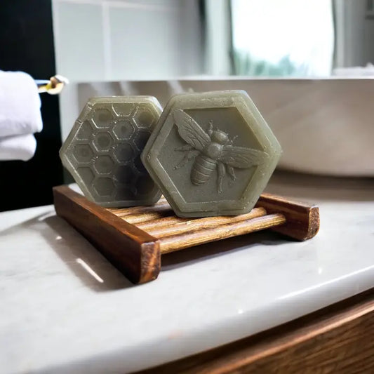 two bars of gray sea clay and honey facial bars sitting on bathroom counter
