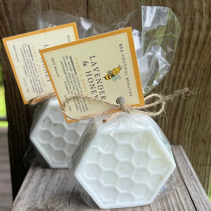 two white honey comb detail soap bars sitting side by side in packaging with large orange tag